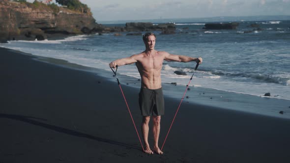 Front to Side Video of Young Sportsman Doing Exercises with Elastic Band alt