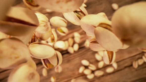Super Slow Motion Shot of Fresh Roasted Pistachio Nuts Falling on Wooden Table at 1000 Fps alt
