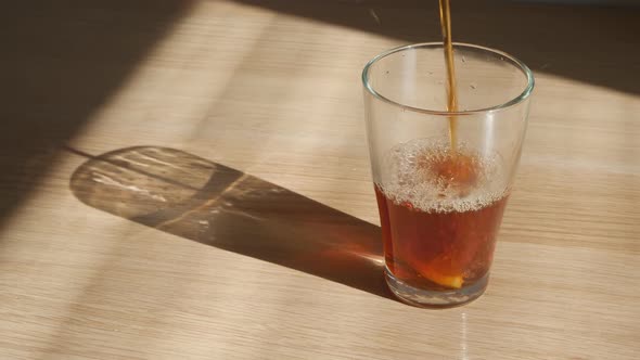 Beautiful Tea Is Poured Into a Large Glass Glass