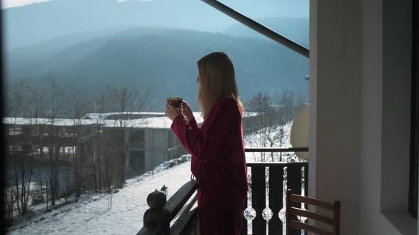Young woman on balcony at chalet. alt