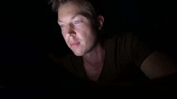 Young Handsome Scandinavian Man Using Digital Tablet in Dark Room