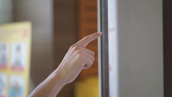 Hand man choosing dessert via self-service machine at fast food restaurant.  alt