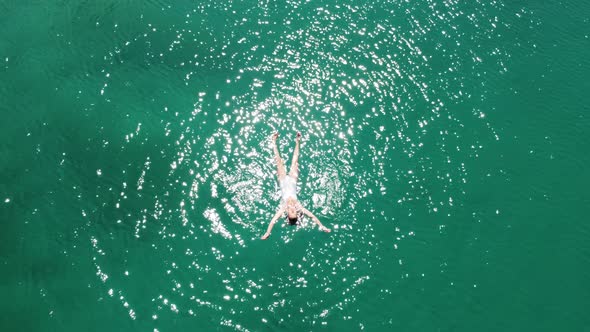 Aerial view of swimming woman in turquoise Lagoon. alt
