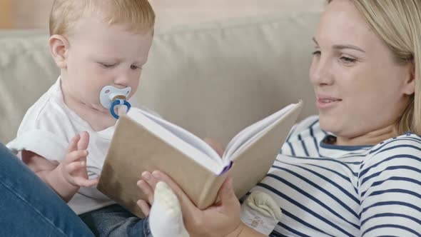 Young Mother Reading Story to Baby alt