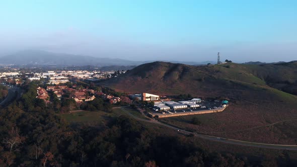 Aerial rotation around a church at sunset in a suburban city. alt