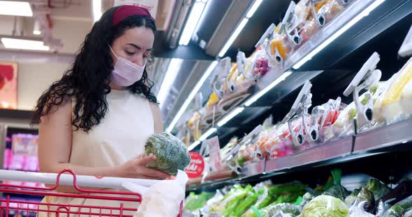 Woman Makes Purchases in a Supermarkethealthy Foodchooses Fresh Vegetables and Puts a Cauliflower in alt