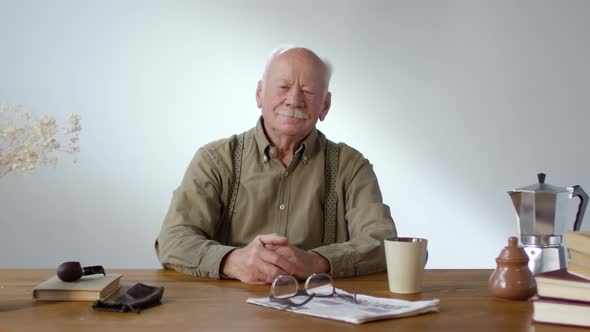 Charismatic Senior Man Sitting at Table alt