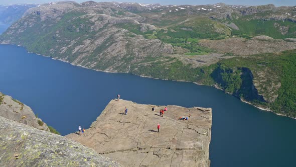 Preikestolen, Aka Preacher’s Chair, Norway. Tourists Enjoying the View Standing on the Edge of the alt