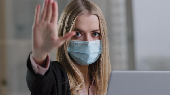 Portrait in Office Caucasian Girl Woman in Medical Face Mask with Laptop Angry Looking at Camera alt
