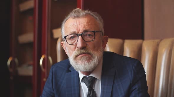 Senior Dramatist Looking at Laptop, Creating Novel While Sitting in Pub. alt