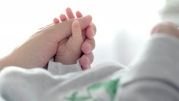 Newborn Baby Hand Holding Mother Mom Touching Baby Tiny Hand to Make Him Feeling Her Love Warm and alt