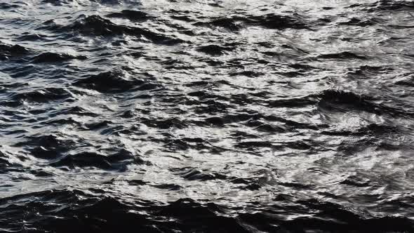 the Reflection of Sun on the Water at Sunset Small Waves Blue Water in Motion alt