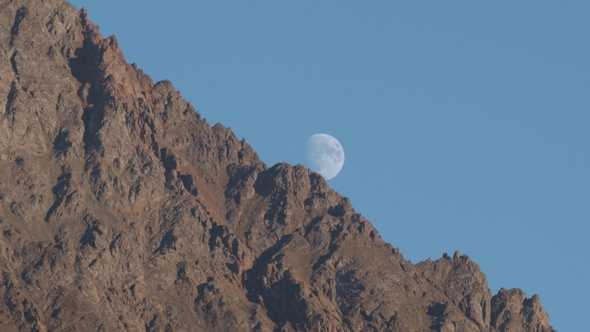 Rising of the Full Moon Before Sunset in the Mountains