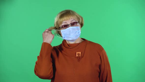 Portrait of Senior Woman Takes Off Her Medical Disposable Mask and Takes a Deep Breat, Isolated Over alt