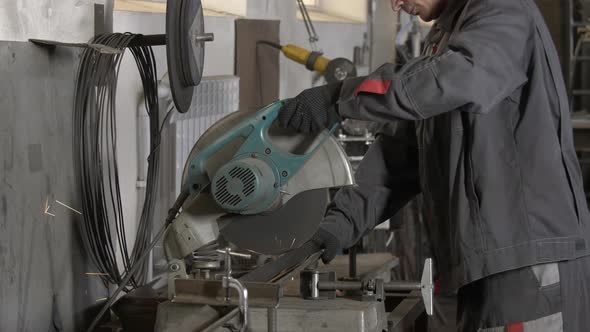 Man Works Circular Saw. Flies of Spark From Hot Metal. Worker Cuts a Circular Saw. Slow Motion