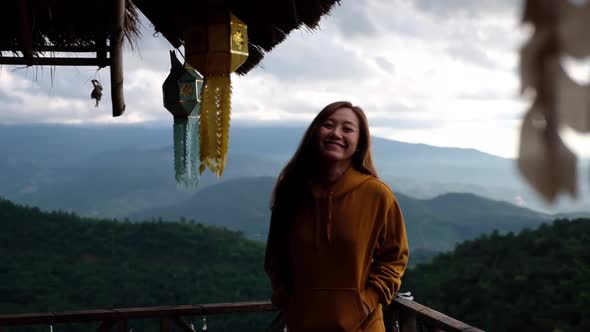 Slow motion of a female traveler walking out of wooden house with a beautiful mountains view