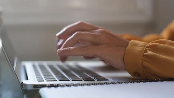 Hands of businesswoman typing on laptop keyboard