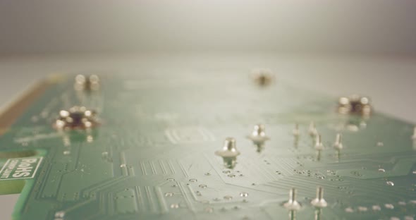 Extreme macro dolly shot of a PCB computer board with capacitors and transistors alt