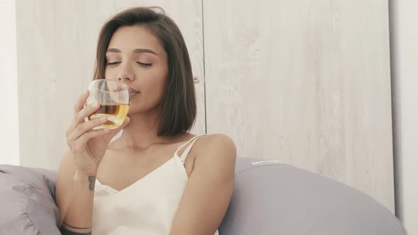 Portrait of young beautiful brunette model posing in white interior alt
