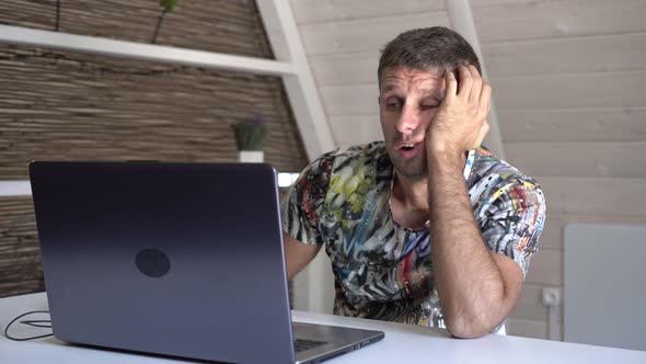 Sleepy Bored Man at Home with Laptop alt