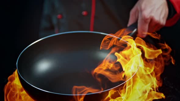 Super Slow Motion Shot of Chef Holding Empty Frying Pan and Flames at 1000Fps alt