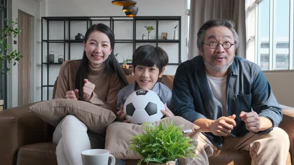Asian family watching football sports games on TV