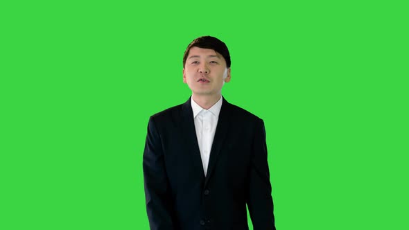 Asian Man in Suit Walking and Speaking on a Green Screen Chroma Key