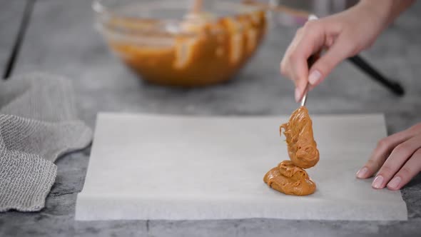 Spreading the Raw Caramel Dough Over a Baking Sheet Parchment Paper