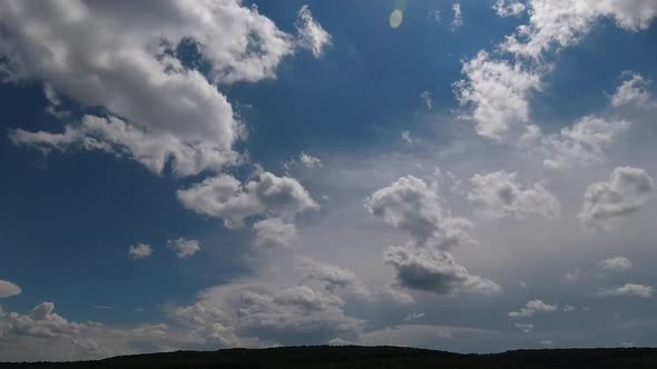 Time lapse: fluffy white clouds are floating by the sky.