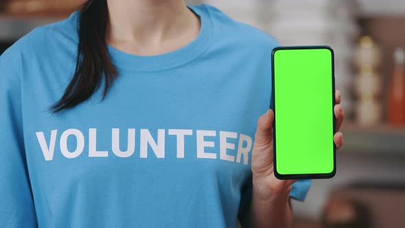 Close Up of Volunteer Holding Mobile with Green Screen alt