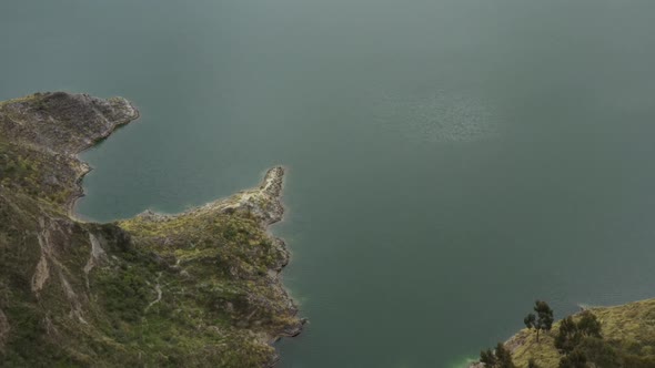 Aerial view flying over the last bit of land decending over the water surface alt