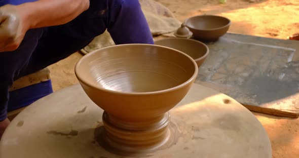 Skilled Hands of Potter Shaping the Clay on Potter Wheel and Sculpting Clay Pot Jar. Shilpagram alt