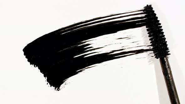 Macro Shot and Slow Motion of a Black Mascara Isolated on White Background alt