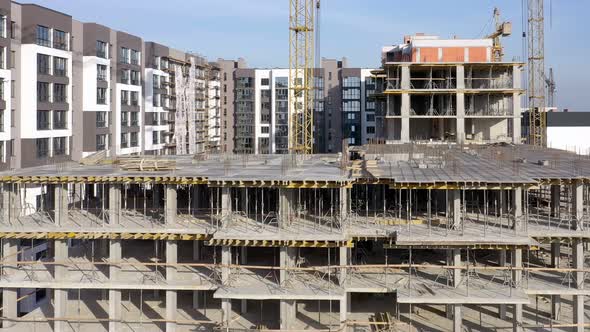Building crane and monolituc building under construction. Construction site alt