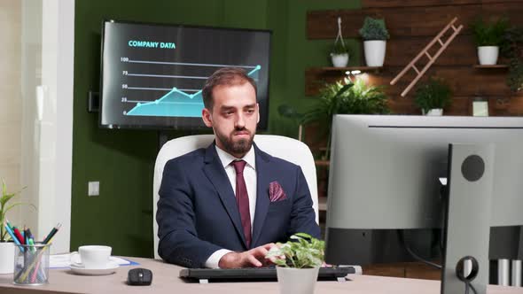 Zoom in Footage of Office Employee Working on the Computer at His Desk alt