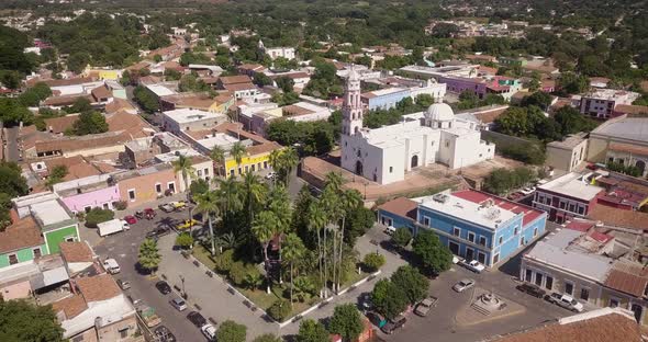 Beautiful significant historic temple in Cosalá village, Mexico. Small colorful houses and park, sun alt