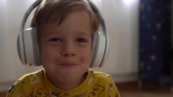 Close Up Handsome Smiling Boy Listening to Music Headphones Indoor