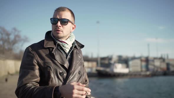 Young Attractive Guy Smoking a Cigarette in the Harbor