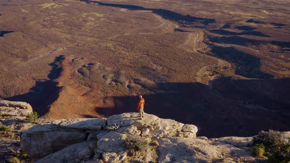 Aerial shot of a hiker at the the edge of Cedar Mesa in Utah alt