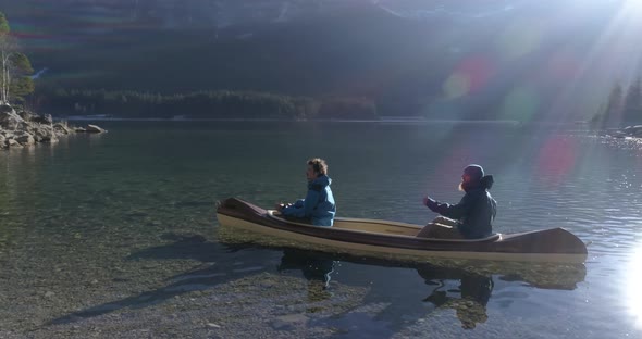 Drone flight around two friends in canoe, Bavaria, Germany