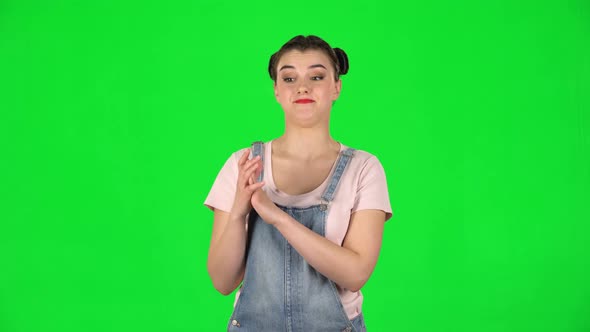 Girl with Two Hair-buns Claps Her Hands Indifferently on Green Screen alt