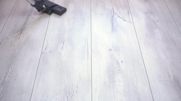 Man Vacuuming Gray Laminate Floor at Home alt
