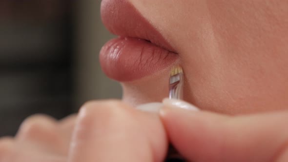 Closeup of a Cosmetologist Painting Lips with a Pencil Before Permanent Makeup alt