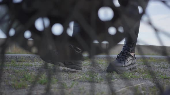 Unrecognizable Girl in Black Shoes and Dress Comes To the Motorcycle and Sits on It alt