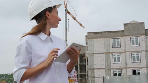 Female Civil Engineer Using a Tablet at Her Workplace on a Construction Site alt