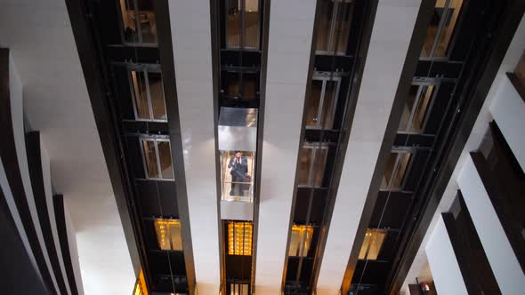Above View of Rising Elevator Car with Hotel Guest alt