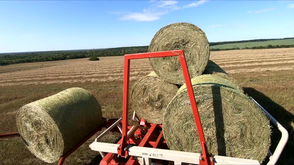 Collecting Haystacks From the Fields, Close-up. Harvesting Hay with Modern Agricultural Technology