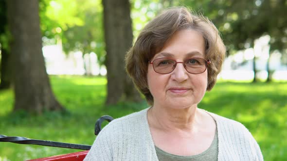 Portrait of a Happy Caucasian Senior Woman with Glasses Look at Camera alt