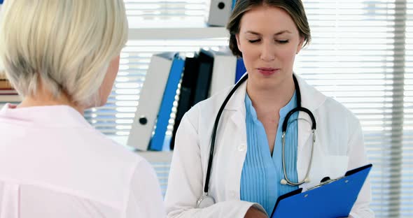 Female doctor interacting over a report with a patient alt