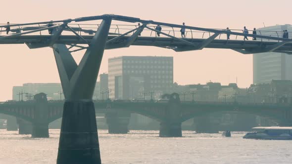 People Crossing Foot Bridge In City alt